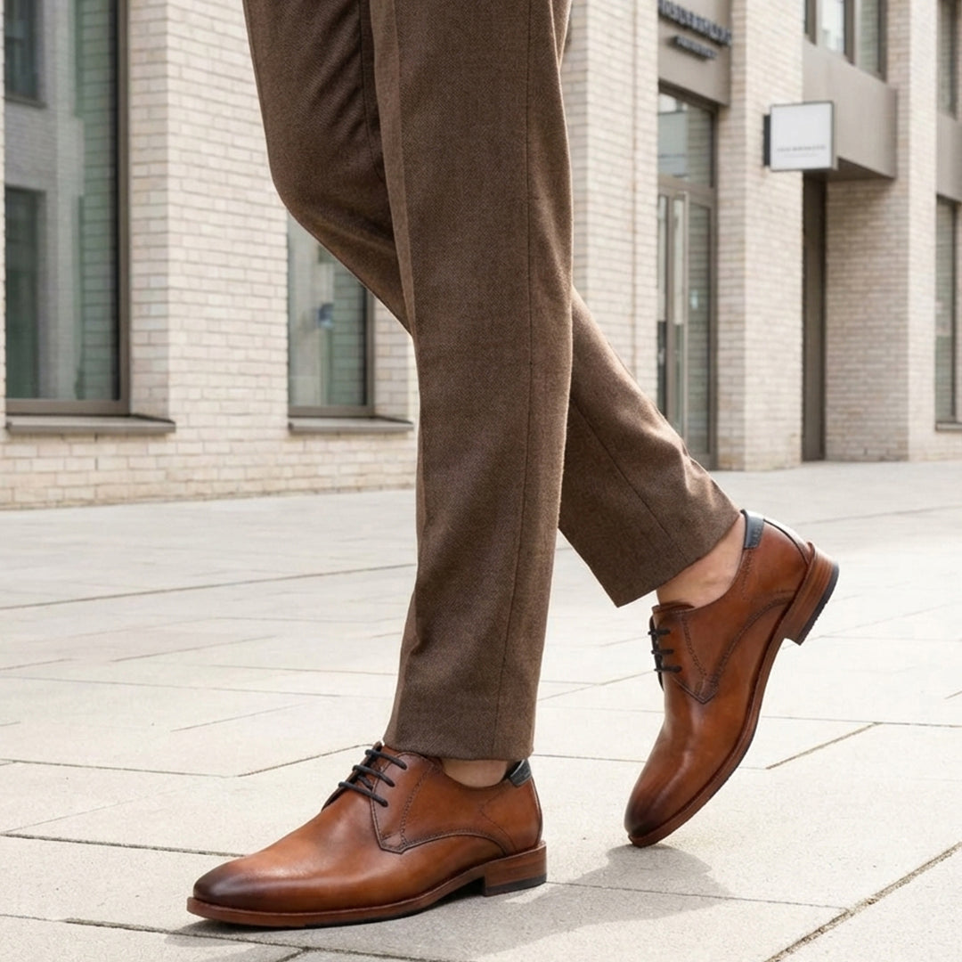 bugatti Lark Flex cognac leather derby shoe with dark laces, worn with brown trousers.
