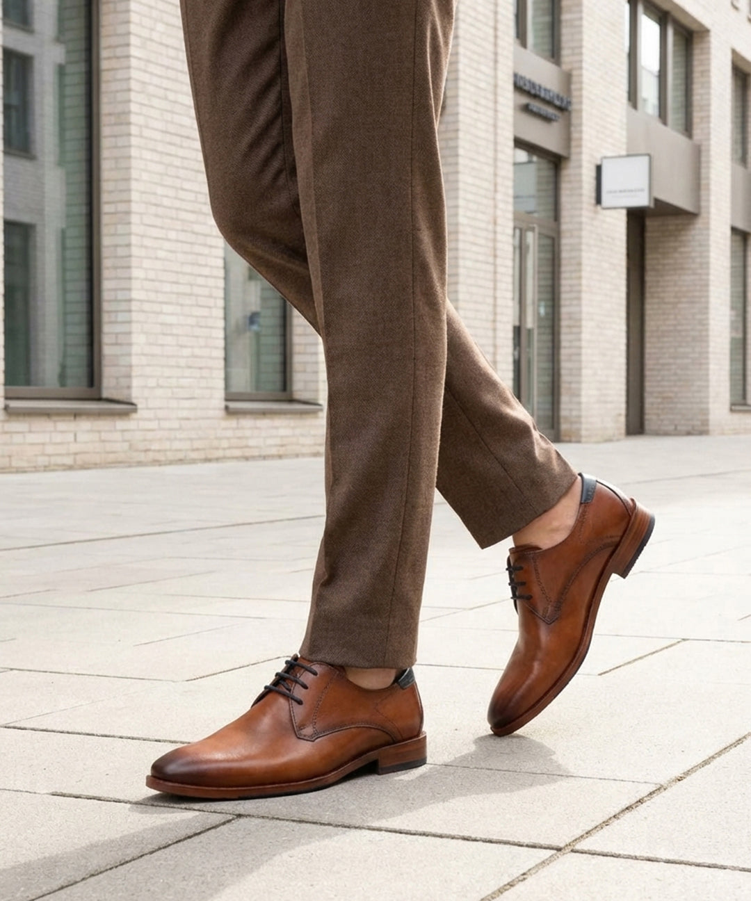 bugatti Lark Flex cognac leather derby shoe with dark laces, worn with brown trousers.
