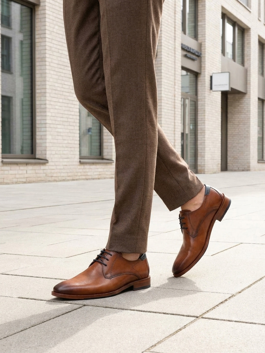 bugatti Lark Flex cognac leather derby shoe with dark laces, worn with brown trousers.
