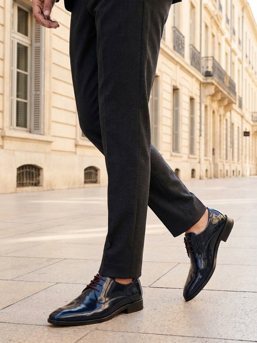 bugatti Lark flex dark blue leather derby shoes with brown laces, shown with gray trousers and a sidewalk.

