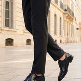 bugatti Lark flex dark blue leather derby shoes with brown laces, shown with gray trousers and a sidewalk.
