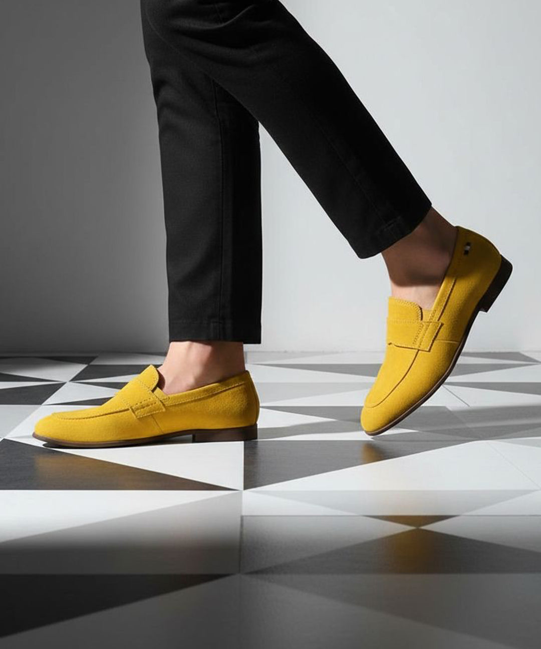 Yellow leather loafers by bugatti on black and white checkered flooring, paired with black trousers.