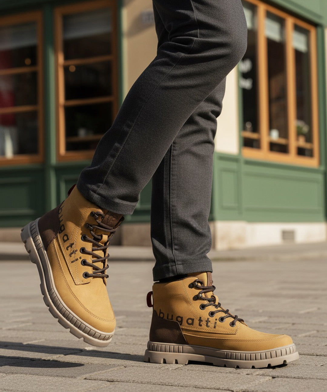 Lifestyle shot of bugatti Pallario beige comfort casual boots with dark brown accents, worn with grey pants.
