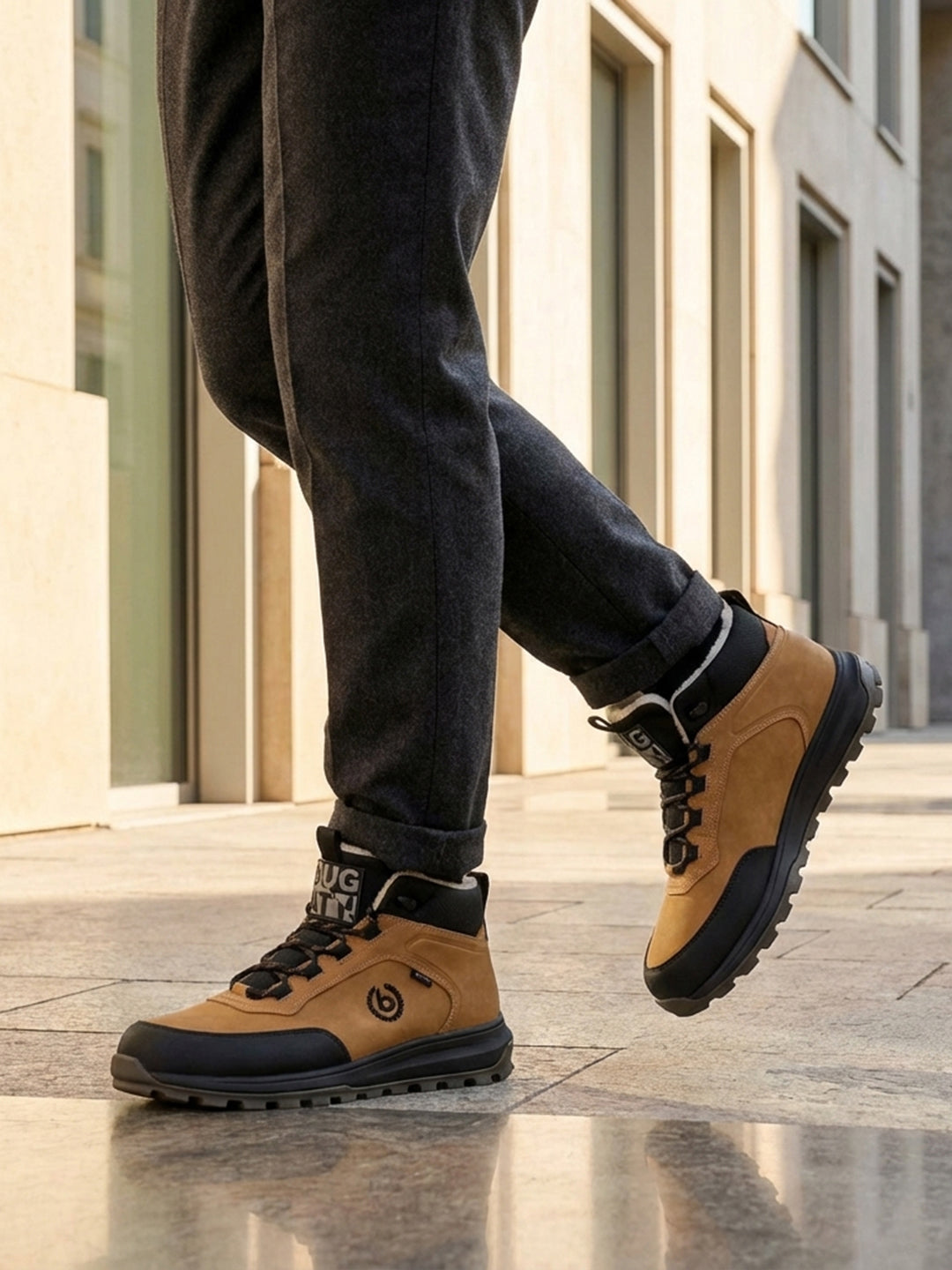 Lifestyle view of bugatti Columb Cognac Comfort Sneakers, with dark trousers and light-colored building in the background.