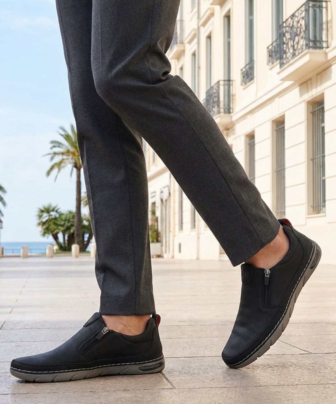 Lifestyle shot of bugatti Glenans black Comfort Slip-Ons casual shoes, paired with gray dress pants.