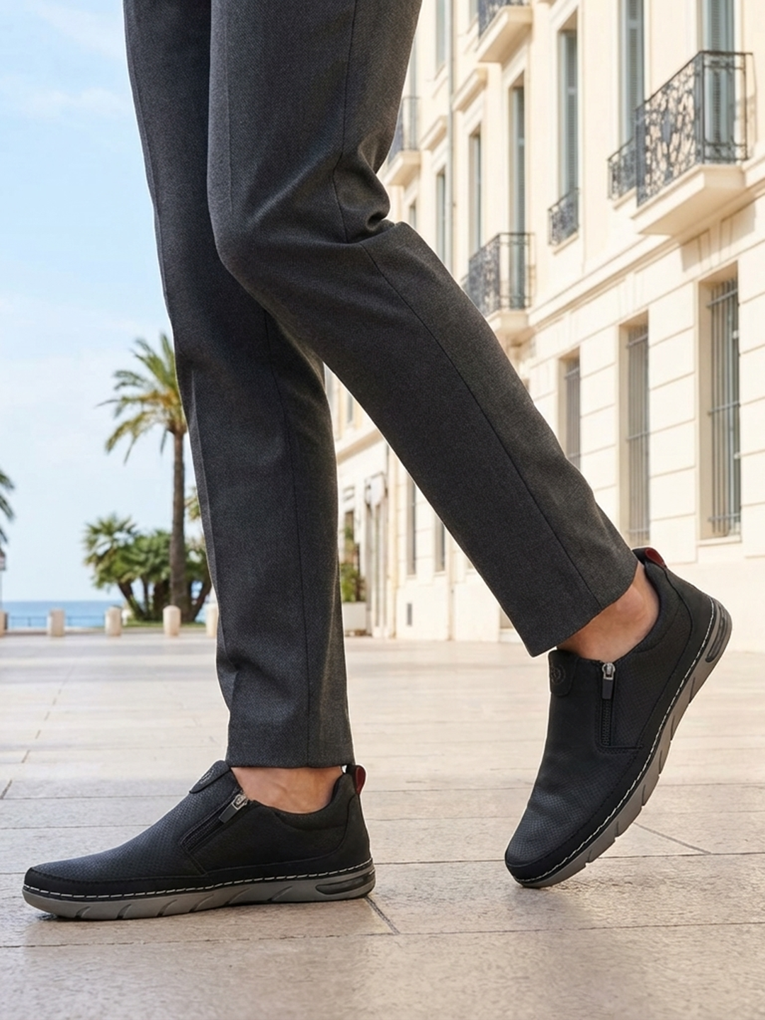 Lifestyle shot of bugatti Glenans black Comfort Slip-Ons casual shoes, paired with gray dress pants.