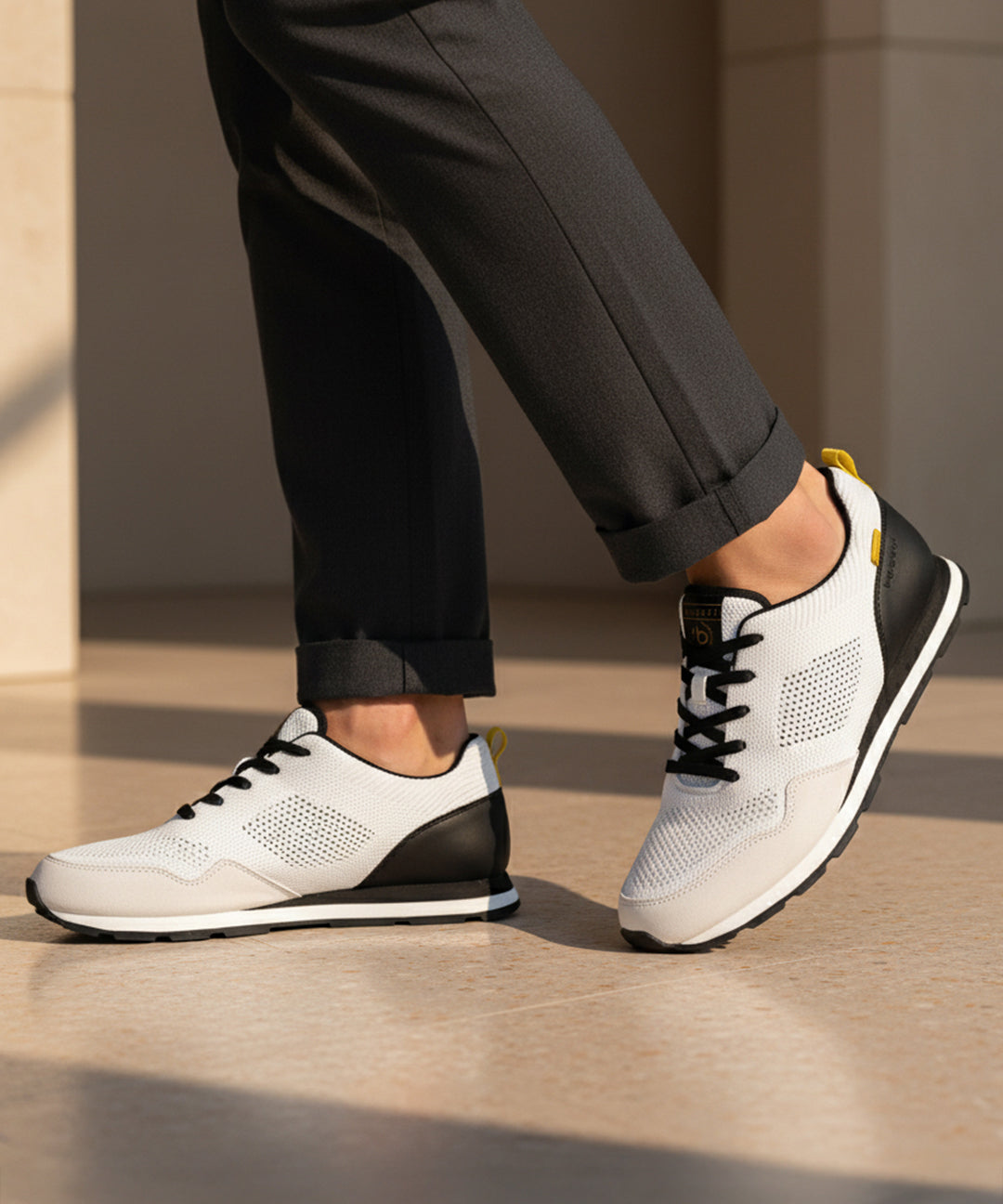 bugatti Sacramento white comfort sneakers with black heel, worn with gray dress pants.
