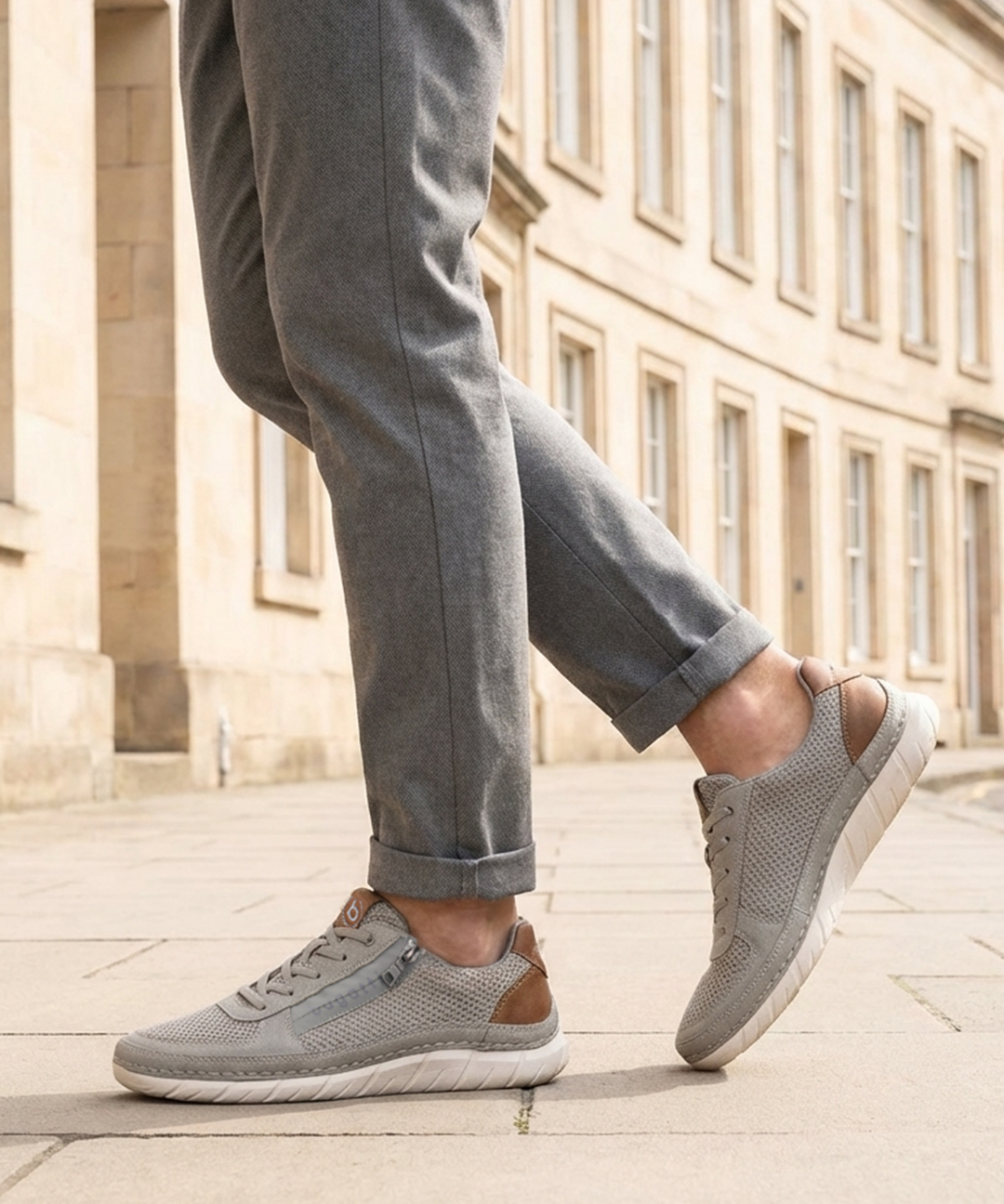 Lifestyle view of bugatti Compton grey comfort sneakers with mesh fabric, leather trim, zipper detail, and white soles.
