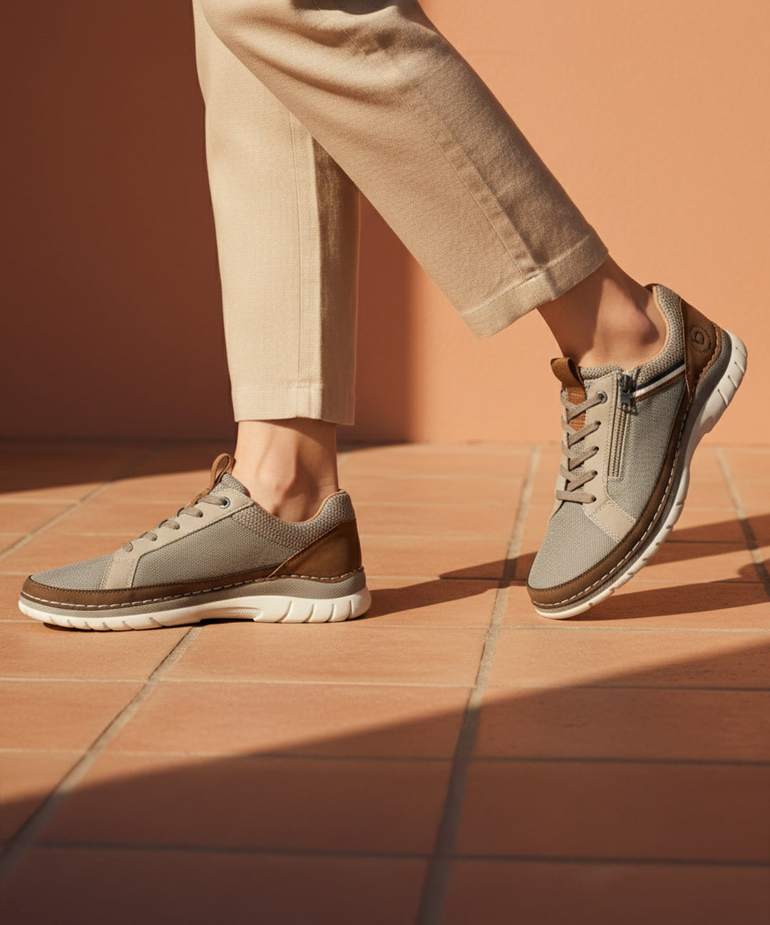 Lifestyle shot of bugatti Rickson beige Comfort Sneakers with zipper detail and brown accents, paired with neutral pants.
