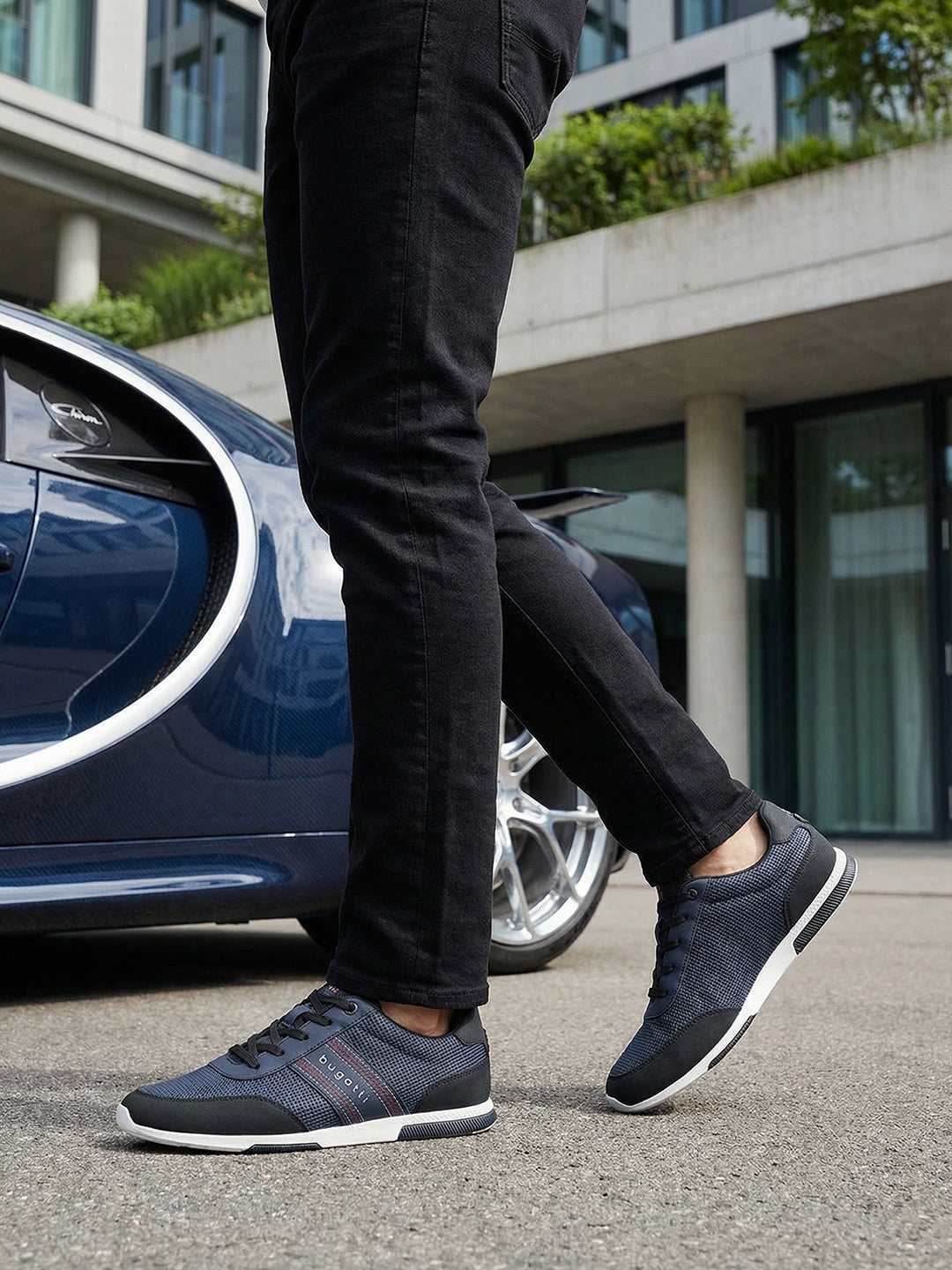 Lifestyle shot of bugatti "Report ECO" dark blue sneakers, with a textured upper, black accents, and a white sole.
