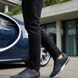 Lifestyle shot of bugatti "Report ECO" dark blue sneakers, with a textured upper, black accents, and a white sole.

