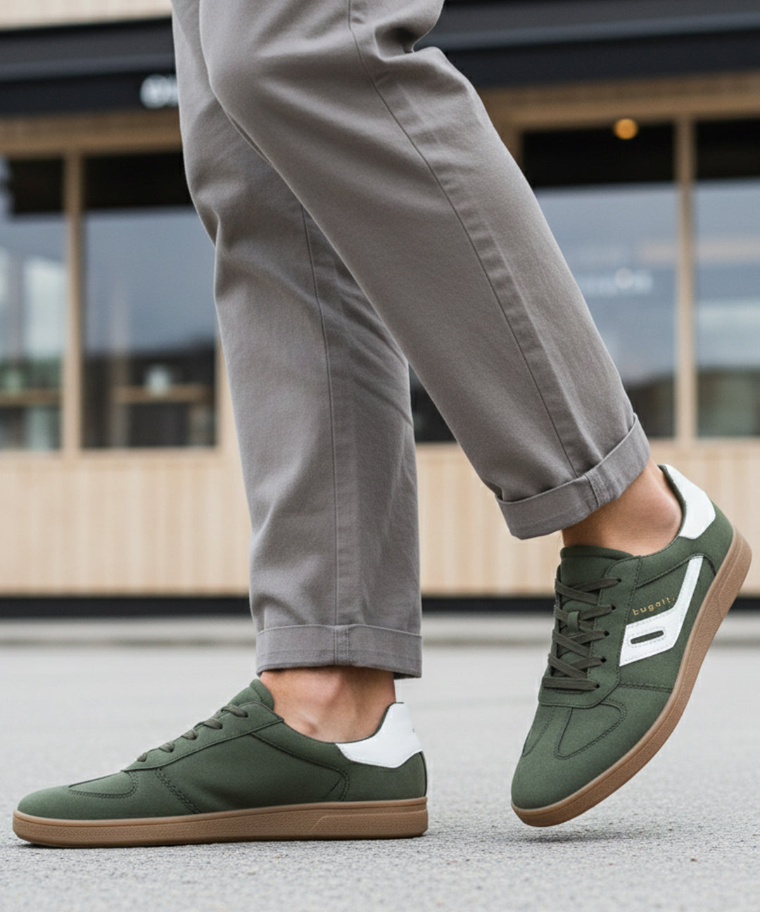 Lifestyle shot of bugatti Carmelo dark green Comfort Sneakers with a white stripe and brown sole.
