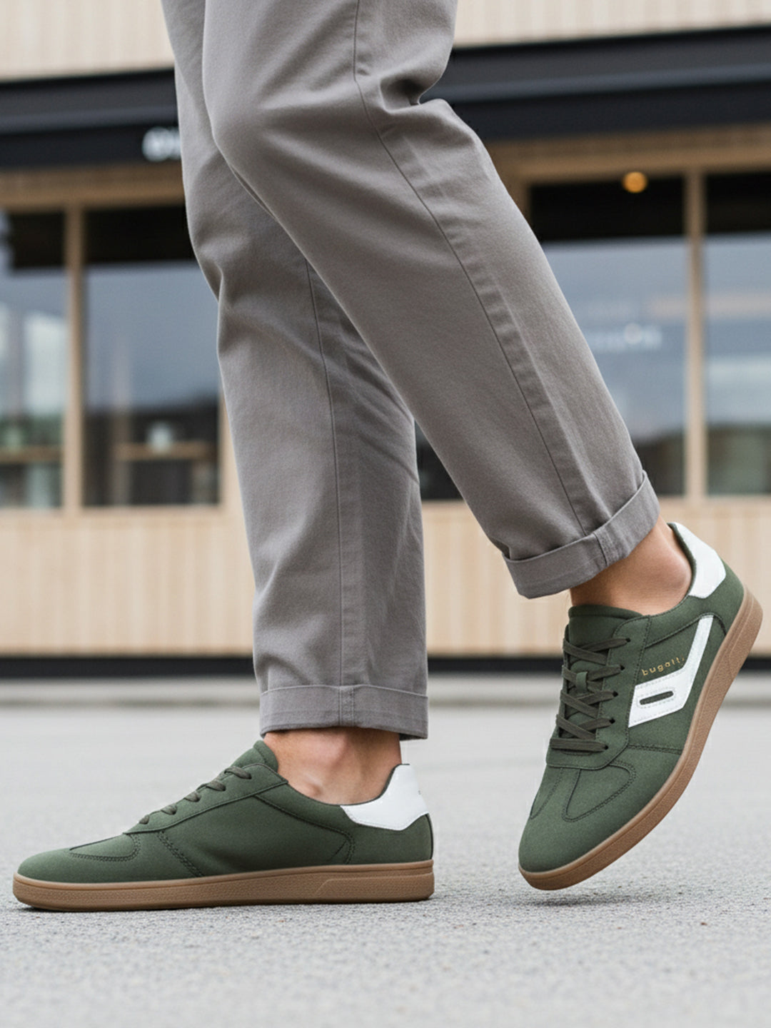 Lifestyle shot of bugatti Carmelo dark green Comfort Sneakers with a white stripe and brown sole.
