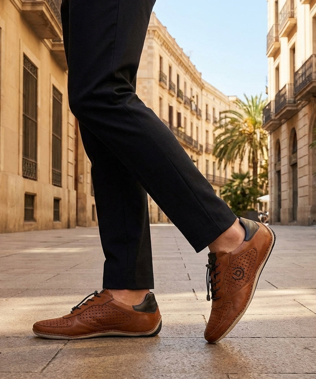 Lifestyle shot of bugatti Canario Cognac Premium Leather Comfort Sneakers worn with black trousers on a city street.