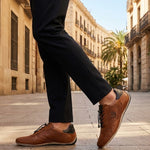Lifestyle shot of bugatti Canario Cognac Premium Leather Comfort Sneakers worn with black trousers on a city street.