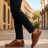 Lifestyle shot of bugatti Canario Cognac Premium Leather Comfort Sneakers worn with black trousers on a city street.
