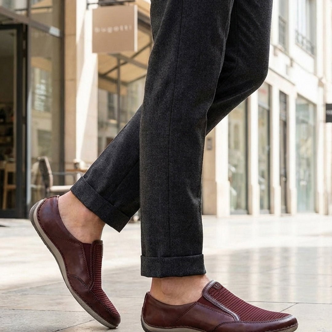 Lifestyle shot of bugatti Canario slip-on shoes in dark red premium leather with mesh detail.
