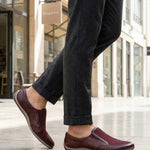 Lifestyle shot of bugatti Canario slip-on shoes in dark red premium leather with mesh detail.
