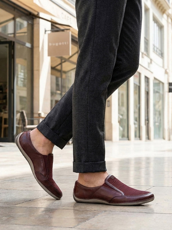 Lifestyle shot of bugatti Canario slip-on shoes in dark red premium leather with mesh detail.
