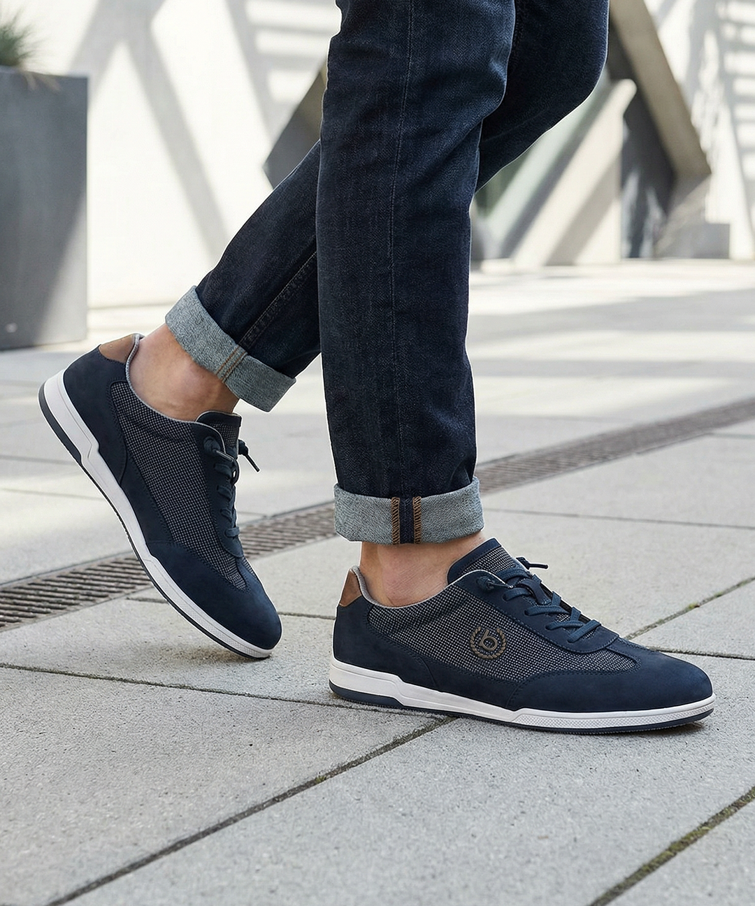 Lifestyle shot of bugatti SOLAR EXKO dark blue sneakers, featuring premium leather, suede and mesh upper, and white soles.
