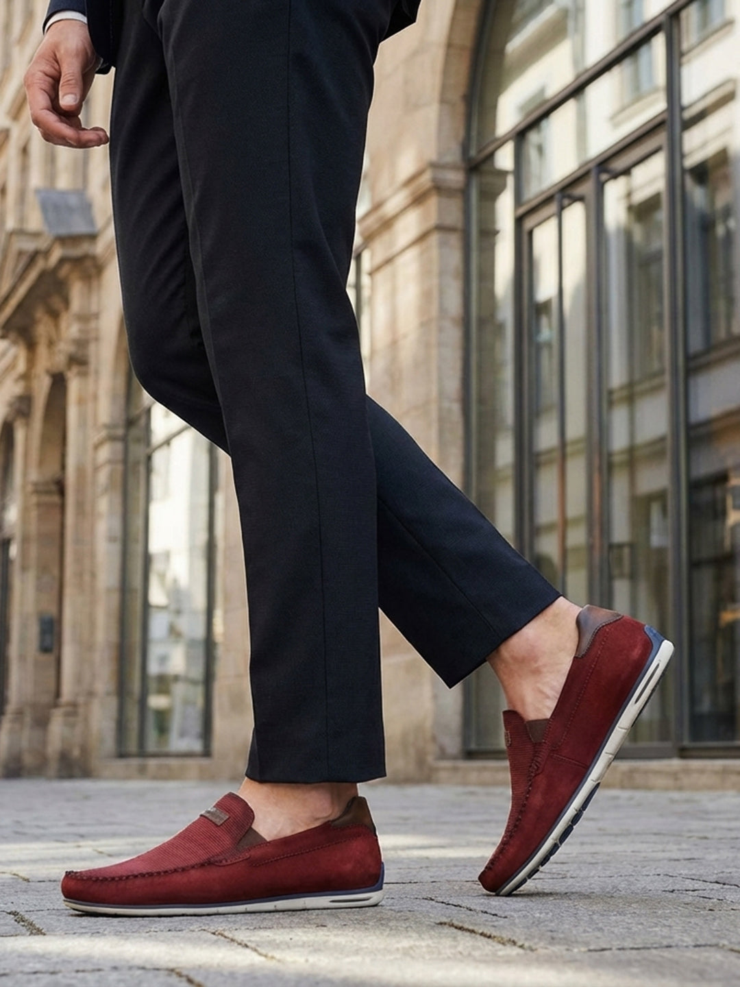 Lifestyle shot of bugatti Chesley dark red leather slip-on shoes, paired with dark dress pants.
