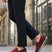 Lifestyle shot of bugatti Chesley dark red leather slip-on shoes, paired with dark dress pants.
