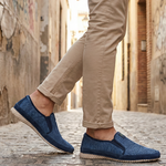 Lifestyle image of bugatti Colville blue casual slip-on shoe with a knit texture and beige sole.
