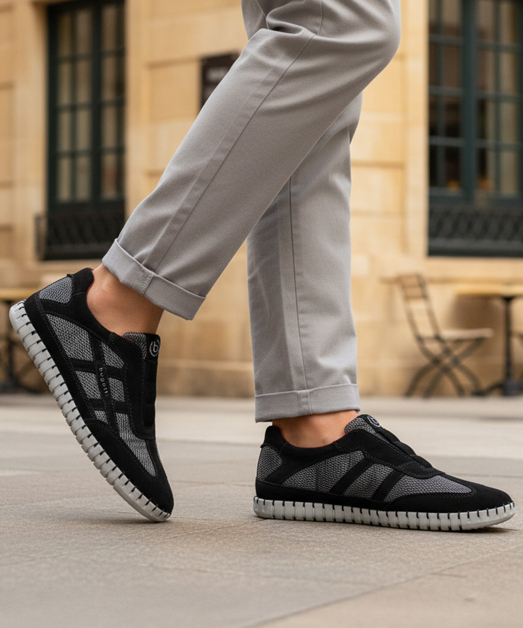 Lifestyle view of bugatti Baloo black leather sneakers with gray mesh detail and a chunky sole.
