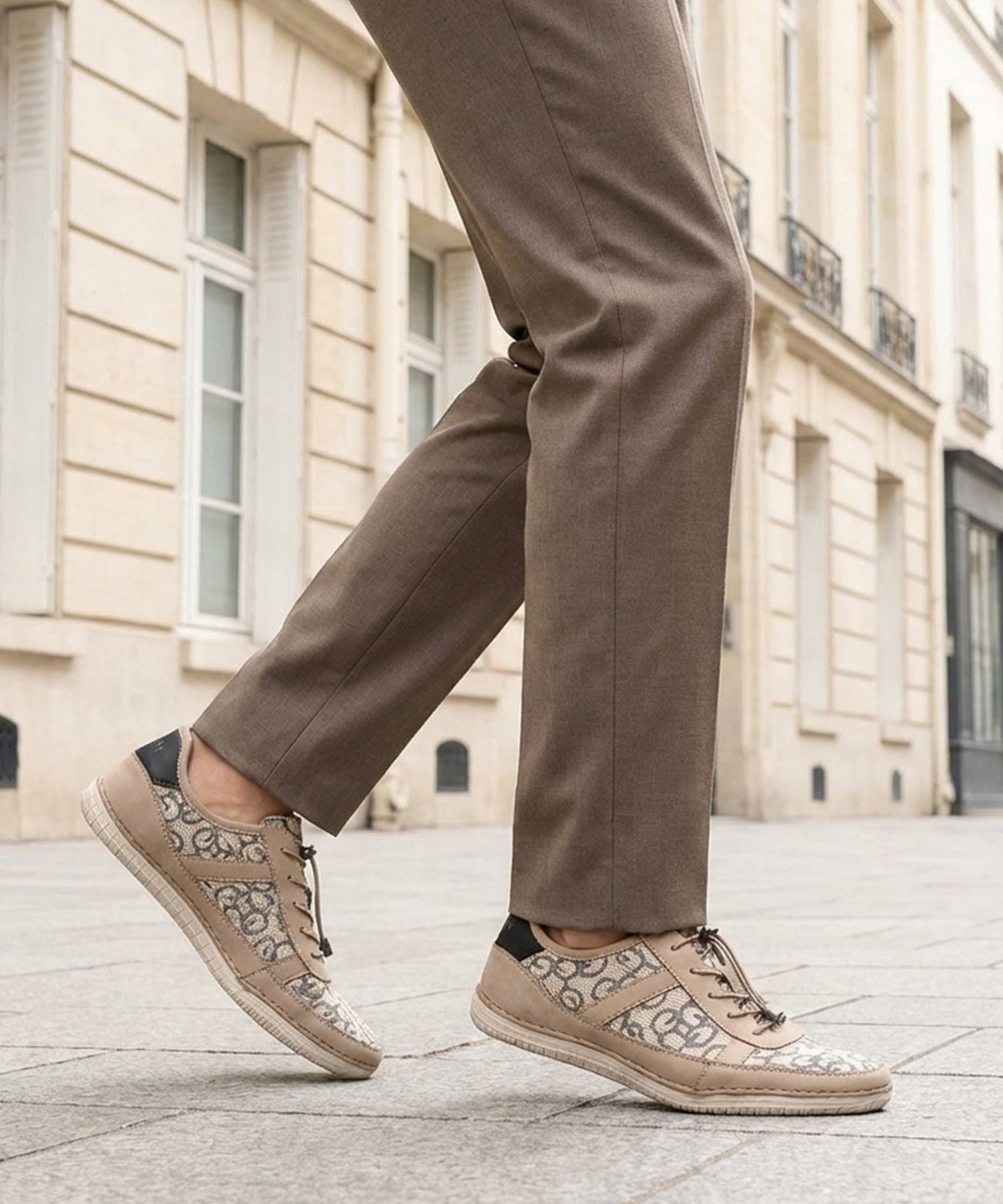 bugatti Bimini beige comfort sneakers with a lace-up closure, complemented by brown trousers, in a lifestyle shot.
