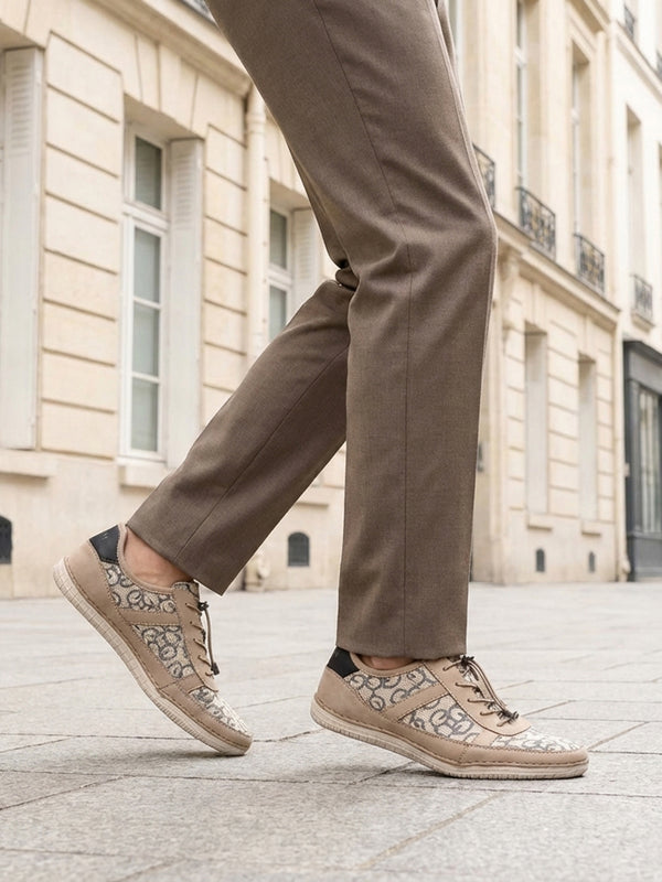 bugatti Bimini beige comfort sneakers with a lace-up closure, complemented by brown trousers, in a lifestyle shot.
