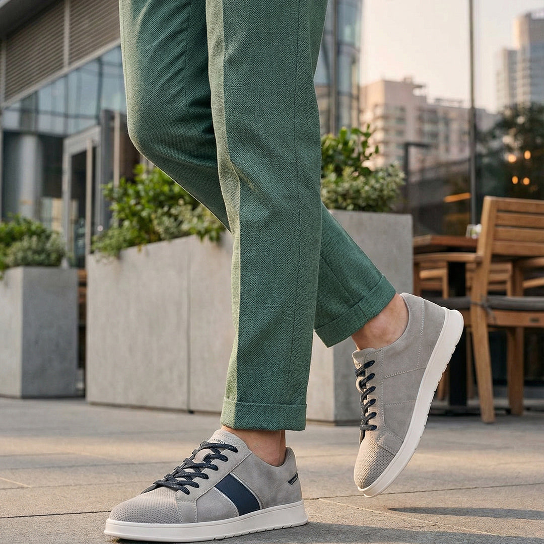 Lifestyle image of bugatti Fiero grey leather sneakers, with dark laces and a navy stripe detail.

