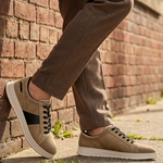 bugatti Fiero beige leather sneakers with black laces and a white sole, worn with brown trousers.
