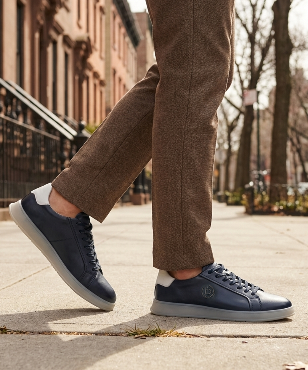 Lifestyle view of bugatti Fiero dark blue leather sneakers with a light grey sole and heel.