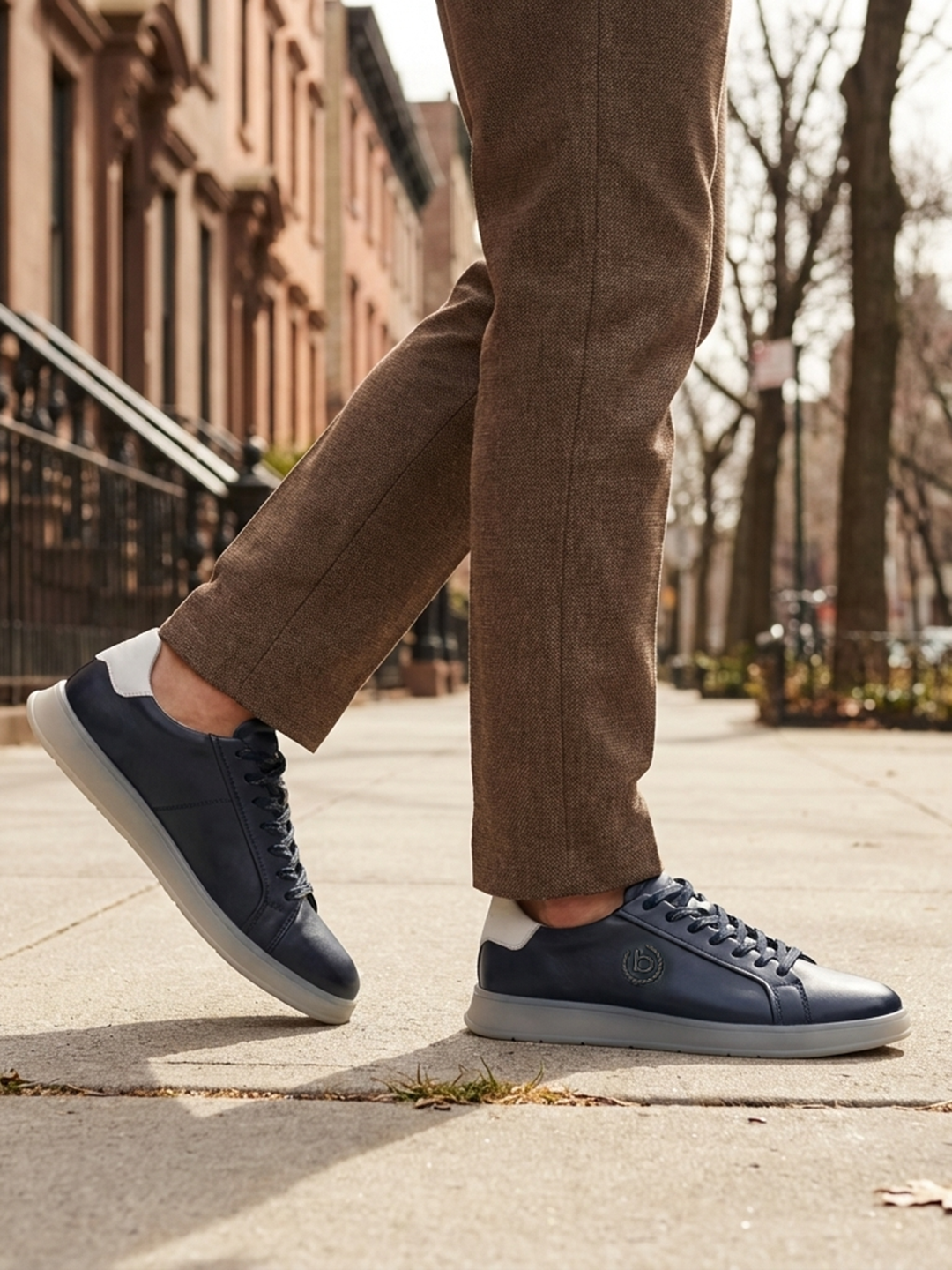 Lifestyle view of bugatti Fiero dark blue leather sneakers with a light grey sole and heel.