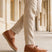 Lifestyle shot of a man wearing bugatti Spendril Cognac leather slip-on shoes with light brown linen pants.