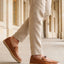 Lifestyle shot of a man wearing bugatti Spendril Cognac leather slip-on shoes with light brown linen pants.