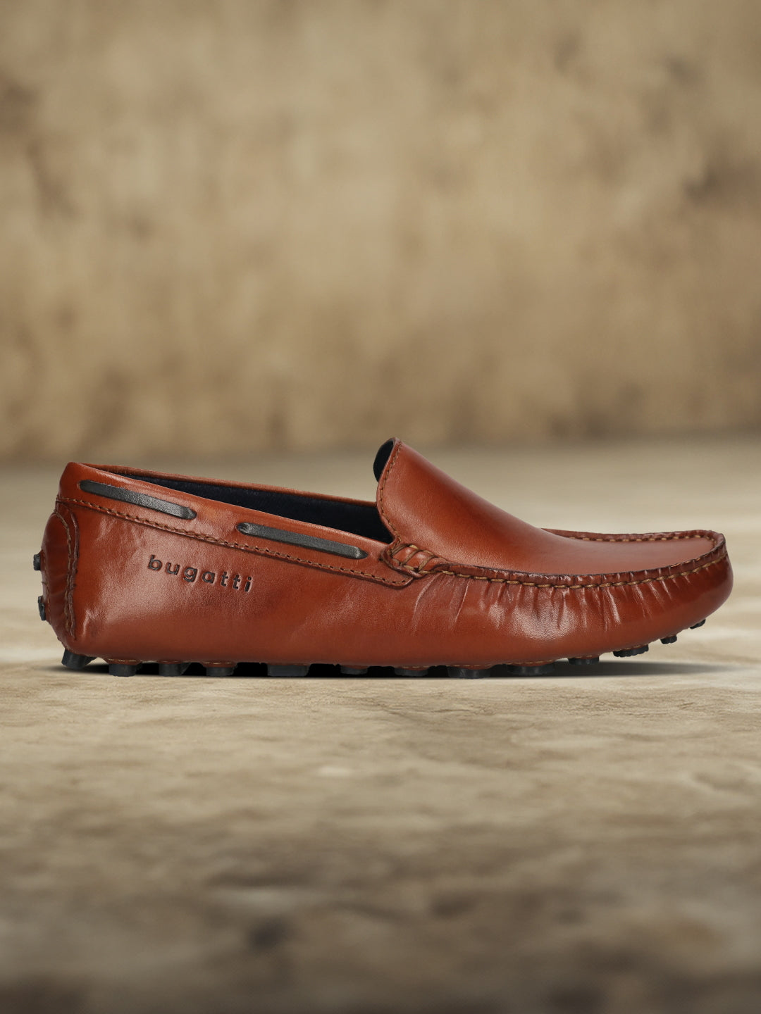 Men's Bugatti drivers cognac leather shoes with a round toe and apron toe , a tpr outsole.