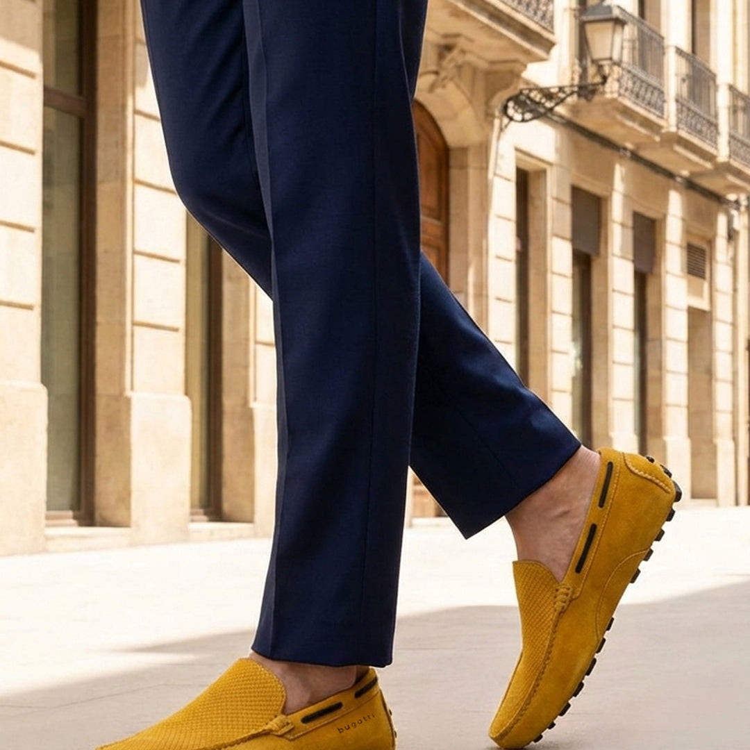Lifestyle cropped image of bugatti Manfield yellow leather slip-on shoes with dark blue slacks.

