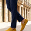 Lifestyle cropped image of bugatti Manfield yellow leather slip-on shoes with dark blue slacks.
