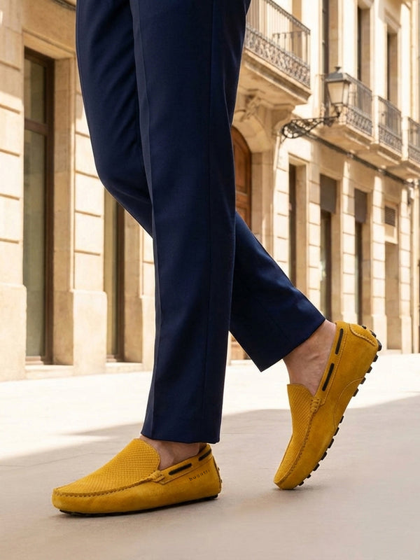 Lifestyle cropped image of bugatti Manfield yellow leather slip-on shoes with dark blue slacks.
