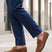 Lifestyle shot of a man wearing bugatti Cobe Cognac leather slip-on shoes with blue dress pants.