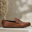 A cognac Men's bugatti Drivers featuring a round toe apron toe, zero heels heel. Made from premium genuine leather with a durable rubber outsole, this slip-on design offers both style and comfort.