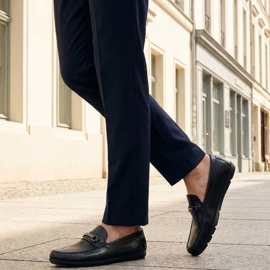 Lifestyle shot of bugatti Cobe Black premium leather slip-on shoes, paired with dark-colored pants.