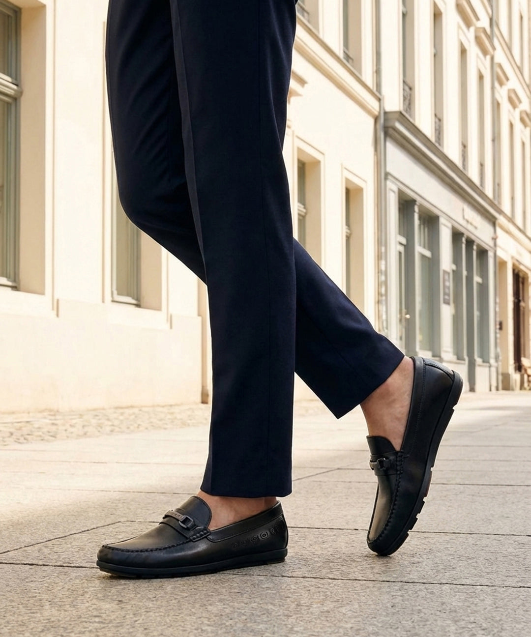 Lifestyle shot of bugatti Cobe Black premium leather slip-on shoes, paired with dark-colored pants.