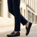 Lifestyle shot of bugatti Cobe Black premium leather slip-on shoes, paired with dark-colored pants.