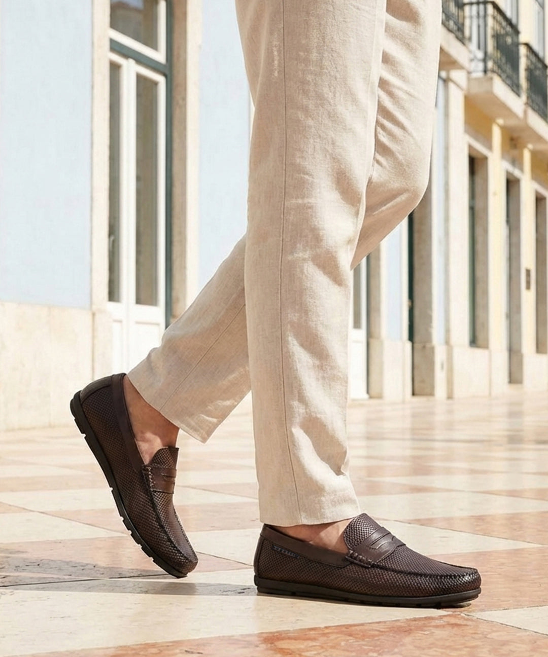 Lifestyle cropped view of a man walking in bugatti dark brown leather slip-on shoes with a basket weave texture.
