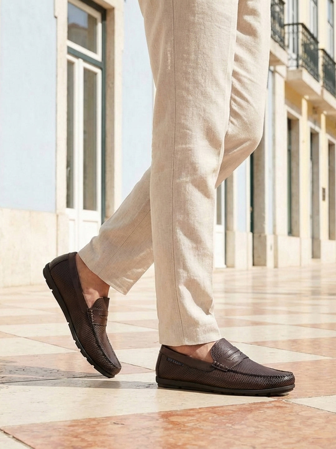 Lifestyle cropped view of a man walking in bugatti dark brown leather slip-on shoes with a basket weave texture.
