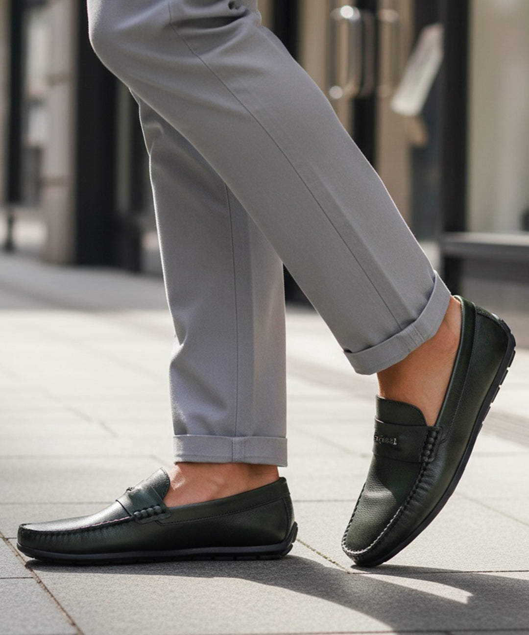 bugatti Linex dark green leather slip-on shoe with visible stitching, worn with gray dress pants.