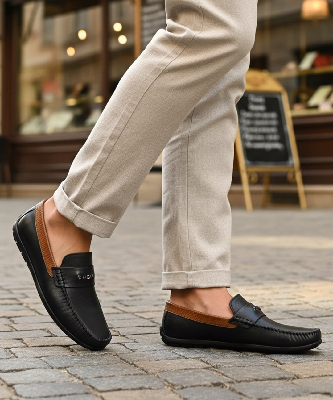 Lifestyle shot of bugatti Linex dark blue leather slip-on shoes with brown accents, paired with beige pants.

