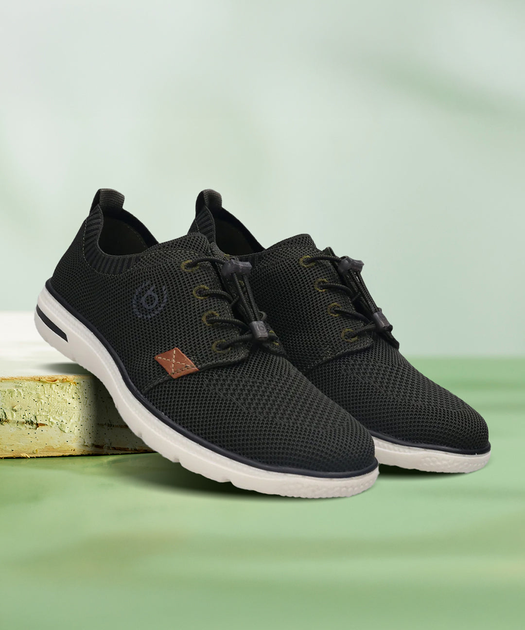 bugatti Bax Comfort dark green sneakers with a knit upper, white sole, and adjustable bungee lacing.